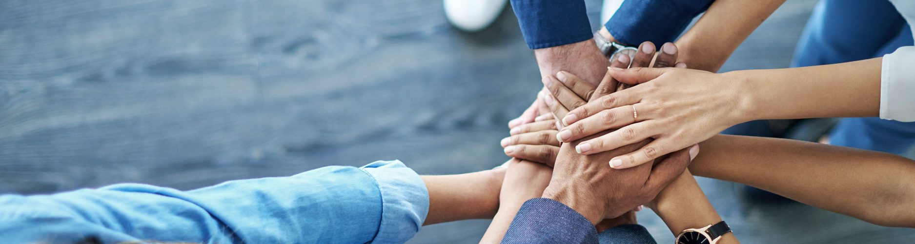 Foto: mehrere Menschen legen ihre Hände übereinander