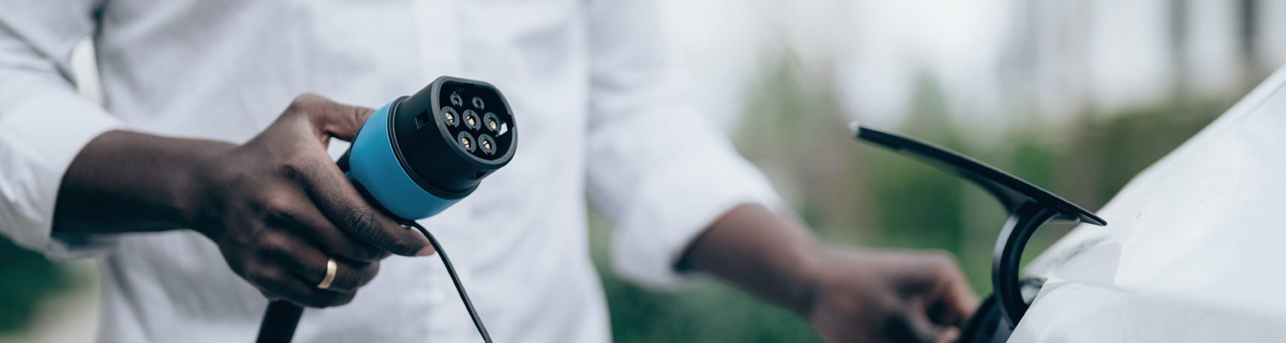 Foto: Mann hält Ladekabel für E-Auto in der Hand