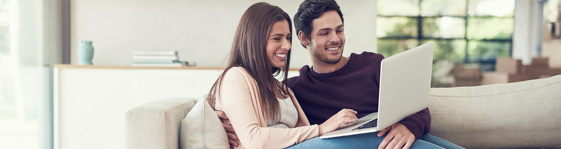 Foto: Junges Paar mit Laptop auf Sofa