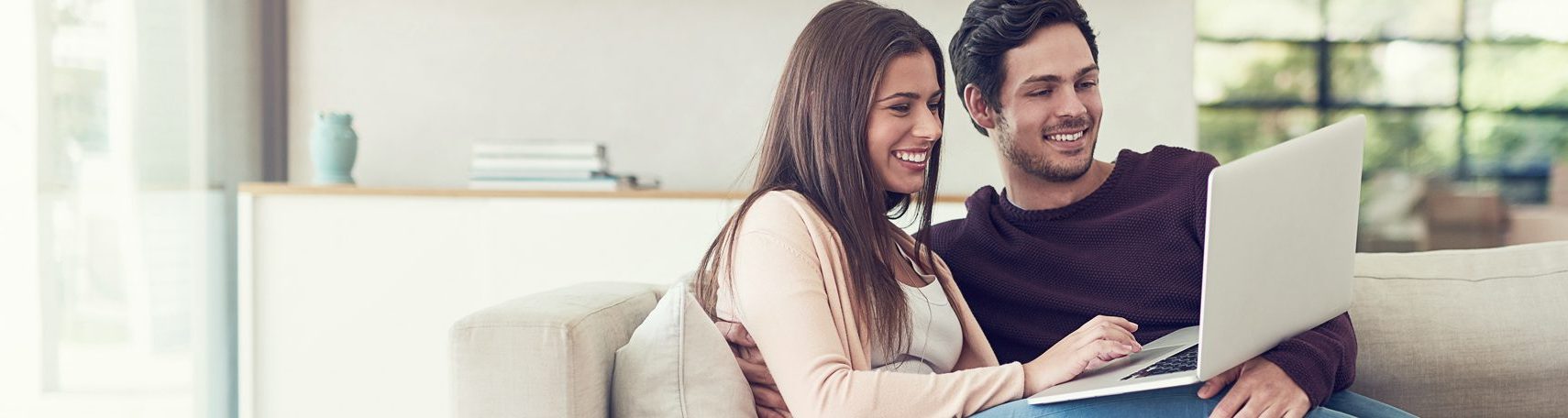 Foto: Junges Paar mit Laptop auf Sofa