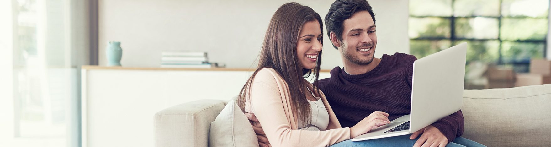 Foto: Junges Paar mit Laptop auf Sofa